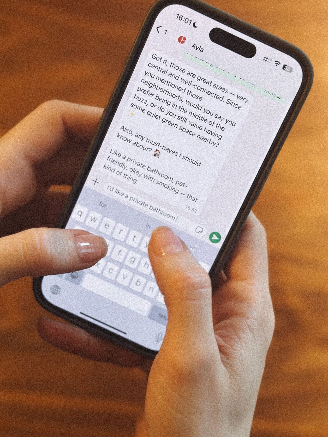 A seeker chatting with Ayla on WhatsApp, phone in hand